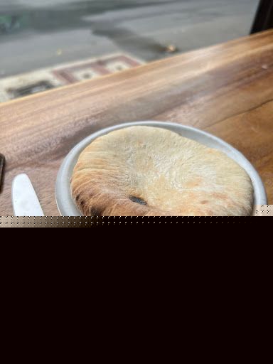 Freshly baked pita bread resting on a plate at LaPita