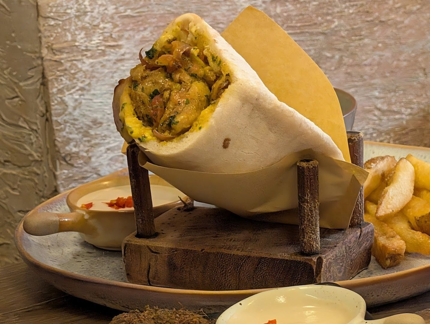 Shawarma wrap in freshly baked pita with fries and tahini dipping sauce