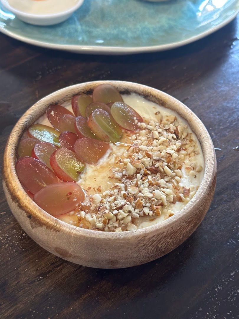 Yogurt bowl topped with fresh grapes and crushed nuts